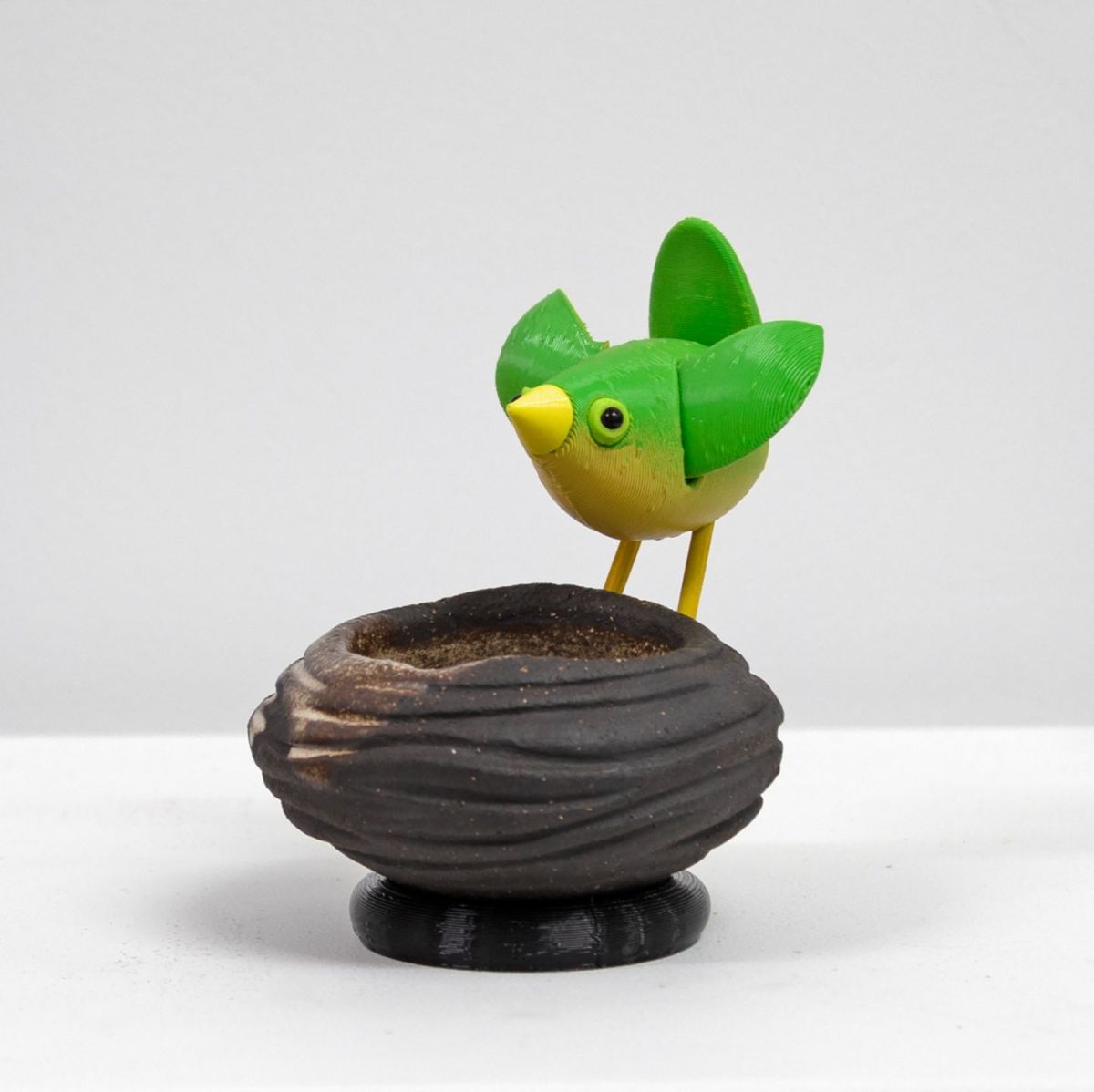 stoneware bird nest II, with green bird by Chris Barnes